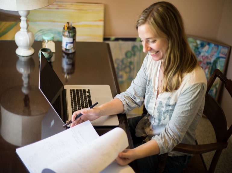 Textile designer working in a creative studio surrounded by fabric and pattern samples
